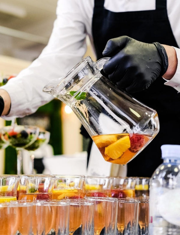 Profissional a servir sangria com fruta em copos para evento