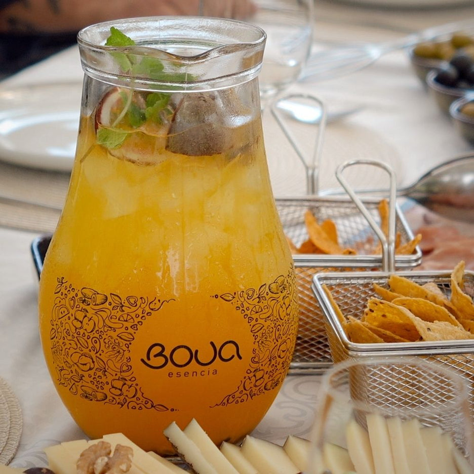 Jarro BOUA Esencia com sangria de cor laranja, gelo, fruta e hortelã