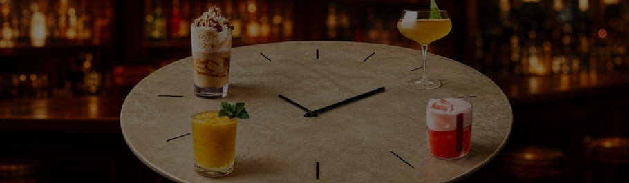 Bebidas criativas servidas sobre uma mesa em forma de relógio num bar