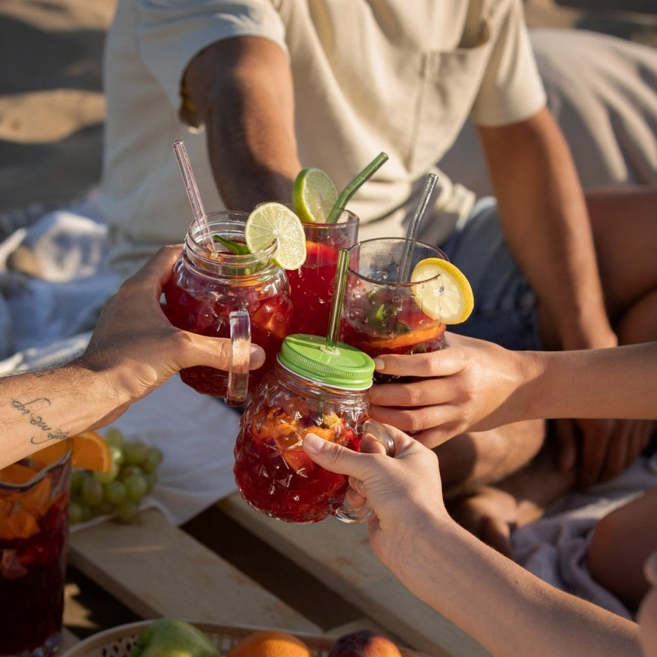 Grupo de amigos a brindar com sangria de frutos vermelhos numa praia